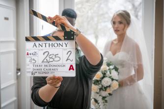 Behind the scenes photo of Anthony featuring clapperboard